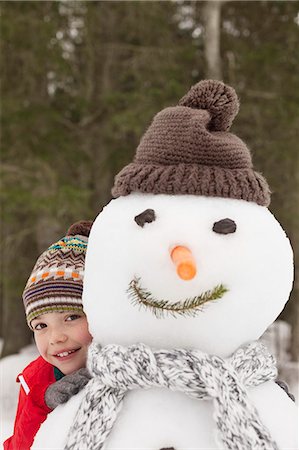 simsearch:6113-06899345,k - Portrait of smiling boy behind snowman with stocking-cap Stock Photo - Premium Royalty-Free, Code: 6113-06899517