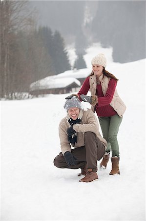 Happy couple enjoying snowball fight in field Stock Photo - Premium Royalty-Free, Code: 6113-06899520