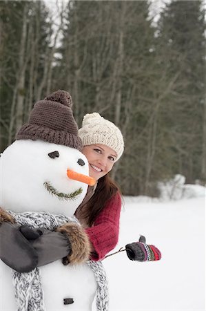 simsearch:6113-06899345,k - Happy woman hugging snowman in woods Stock Photo - Premium Royalty-Free, Code: 6113-06899522