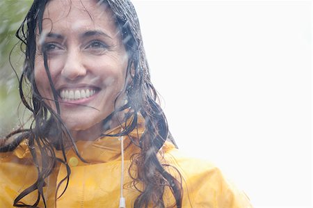 Smiling woman in rain Stock Photo - Premium Royalty-Free, Code: 6113-06899531