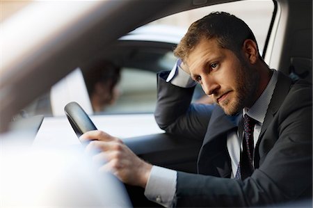 Unhappy businessman stuck in traffic inside car Stock Photo - Premium Royalty-Free, Code: 6113-06899681