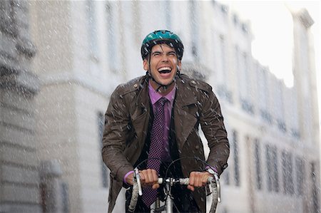 simsearch:6113-08171298,k - Enthusiastic businessman riding bicycle in rain Photographie de stock - Premium Libres de Droits, Code: 6113-06899600