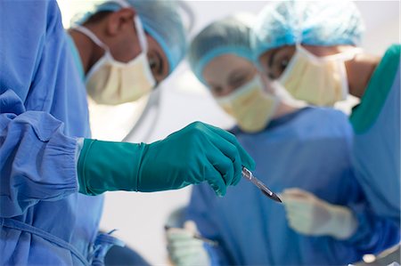 Surgeon holding knife in operating room Stock Photo - Premium Royalty-Free, Code: 6113-06908261
