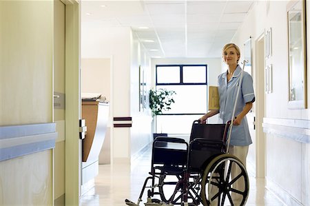 Nurse pushing wheelchair in hospital hallway Stock Photo - Premium Royalty-Free, Code: 6113-06908283