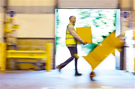 dolly - Blurred view of workers carrying boxes in warehouse Stock Photo - Premium Royalty-Free, Code: 6113-06908394