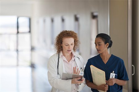simsearch:6113-07146726,k - Doctor and nurse talking in hospital hallway Stock Photo - Premium Royalty-Free, Code: 6113-06908301