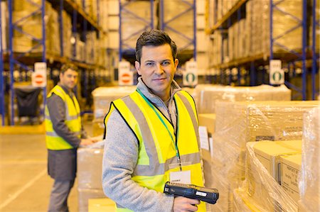 Worker scanning boxes in warehouse Stock Photo - Premium Royalty-Free, Code: 6113-06908333