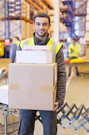 Worker carrying boxes in warehouse Stock Photo - Premium Royalty-Free, Code: 6113-06908447