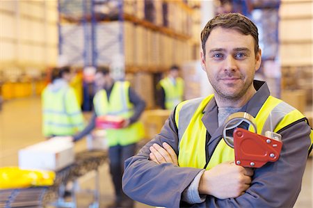 simsearch:6113-07160283,k - Worker holding tape dispenser in warehouse Stock Photo - Premium Royalty-Free, Code: 6113-06908460