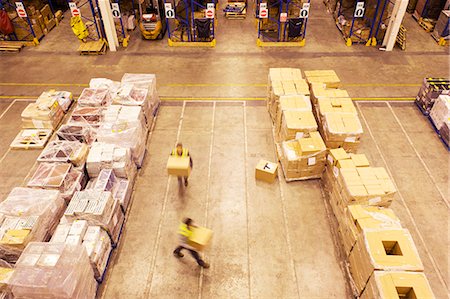 Blurred view of workers carrying boxes in warehouse Stock Photo - Premium Royalty-Free, Code: 6113-06908420