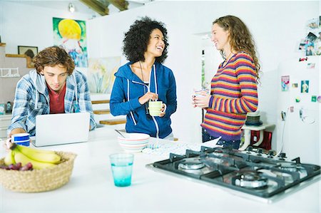 simsearch:6113-06908559,k - Friends relaxing together in kitchen Foto de stock - Sin royalties Premium, Código: 6113-06908524