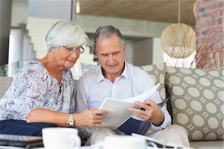 simsearch:6113-07731119,k - Older couple reading papers together on sofa Stock Photo - Premium Royalty-Free, Code: 6113-06908696