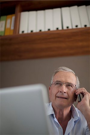 senior technology - Older man talking on cell phone at desk Photographie de stock - Premium Libres de Droits, Code: 6113-06908733