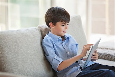 simsearch:6113-06908842,k - Boy using tablet computer on sofa Stock Photo - Premium Royalty-Free, Code: 6113-06908842