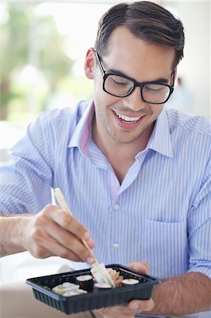 Businessman eating sushi in office Stock Photo - Premium Royalty-Free, Code: 6113-06908933