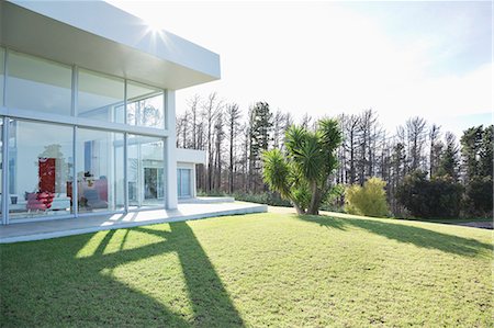 Modern house casting shadows on manicured lawn Photographie de stock - Premium Libres de Droits, Code: 6113-06909039