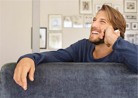 Man talking on cell phone on sofa Stock Photo - Premium Royalty-Free, Code: 6113-06909264