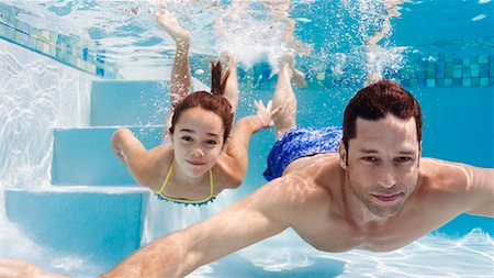 swimming men picture - Father and daughter swimming in pool Stock Photo - Premium Royalty-Free, Code: 6113-06909296
