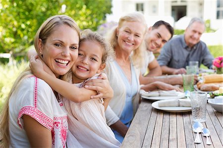 daughter middle-aged mother women young adults - Mother and daughter hugging at table outdoors Stock Photo - Premium Royalty-Free, Code: 6113-06909453