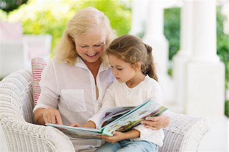 photo of person sitting on porch - Older woman reading to granddaughter on porch Stock Photo - Premium Royalty-Free, Code: 6113-06909465