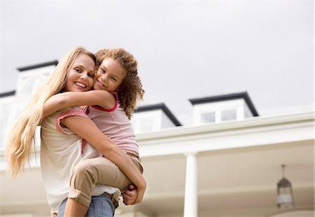 simsearch:6113-06909372,k - Mother and daughter hugging outside house Stock Photo - Premium Royalty-Free, Code: 6113-06909411
