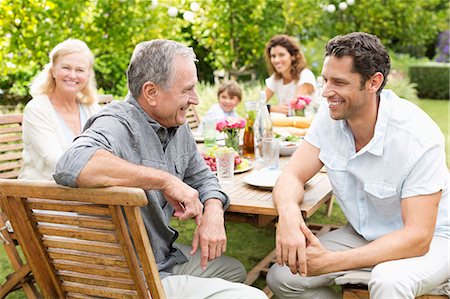 Family sitting at table outdoors Stock Photo - Premium Royalty-Free, Code: 6113-06909422