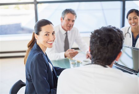 sitting down with doctor - Businesswoman smiling in meeting Stock Photo - Premium Royalty-Free, Code: 6113-07146720