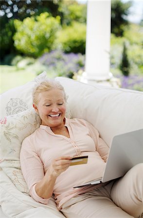 Senior woman shopping online on patio sofa Photographie de stock - Premium Libres de Droits, Code: 6113-07146873