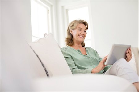 Senior woman using digital tablet on sofa Foto de stock - Sin royalties Premium, Código: 6113-07146835