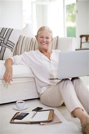 Senior woman using laptop on living room floor Stock Photo - Premium Royalty-Free, Code: 6113-07146903