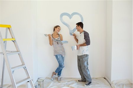 Couple painting blue heart on wall Foto de stock - Sin royalties Premium, Código: 6113-07147202