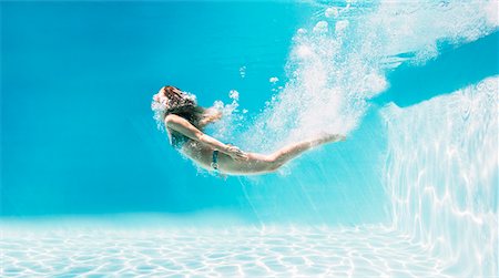 simsearch:6113-07147417,k - Woman swimming underwater in swimming pool Stock Photo - Premium Royalty-Free, Code: 6113-07147417