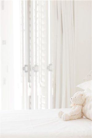 Teddy bear on white bed Stock Photo - Premium Royalty-Free, Code: 6113-07147519