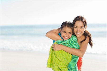 Mother wrapping daughter in towel on beach Stock Photo - Premium Royalty-Free, Code: 6113-07147796