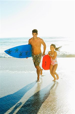 Father and daughter carrying surfboard and bodyboard on beach Foto de stock - Sin royalties Premium, Código: 6113-07147730