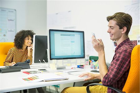 simsearch:6113-07543477,k - Businessman using cell phone at desk in office Stock Photo - Premium Royalty-Free, Code: 6113-07147837