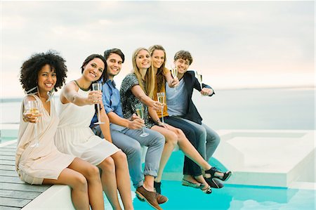 pool party - Friends toasting champagne flutes on footbridge over swimming pool Stock Photo - Premium Royalty-Free, Code: 6113-07148080