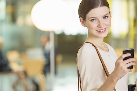 Businesswoman using cell phone in office Stock Photo - Premium Royalty-Free, Code: 6113-07158930