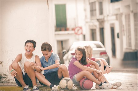 simsearch:6113-07159174,k - Children with soccer balls laughing on city street Stock Photo - Premium Royalty-Free, Code: 6113-07159153