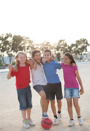 Children playing with soccer ball in sand Stock Photo - Premium Royalty-Free, Code: 6113-07159164