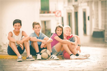 simsearch:6113-07159174,k - Children with soccer balls sitting on city street Stock Photo - Premium Royalty-Free, Code: 6113-07159171