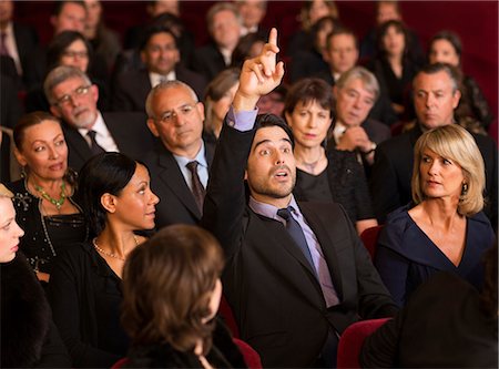 simsearch:6113-07159351,k - Man raising hand in theater audience Foto de stock - Sin royalties Premium, Código: 6113-07159387