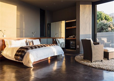 Armchair and bed in modern bedroom Stockbilder - Premium RF Lizenzfrei, Bildnummer: 6113-07159458