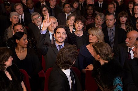 simsearch:6113-07159351,k - Man raising hand in theater audience Foto de stock - Sin royalties Premium, Código: 6113-07159401