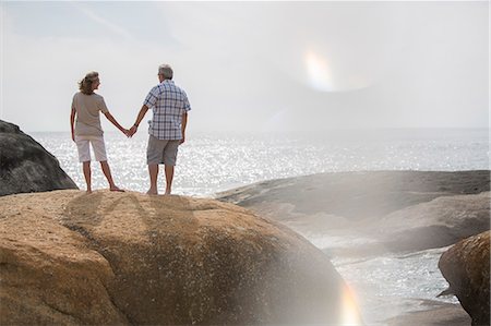 Senior couple holding hands on rocks at beach Foto de stock - Sin royalties Premium, Código: 6113-07159543