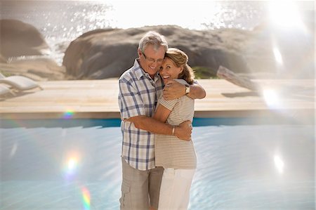 Older couple hugging by pool Stock Photo - Premium Royalty-Free, Code: 6113-07159609