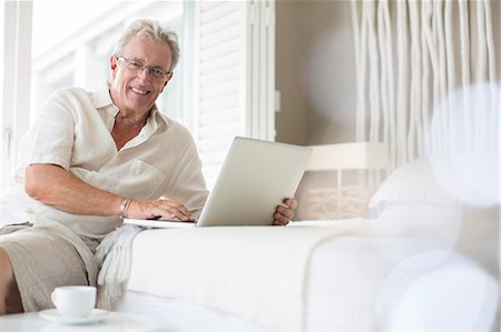 senior technology - Older man using laptop on bed Photographie de stock - Premium Libres de Droits, Code: 6113-07159617