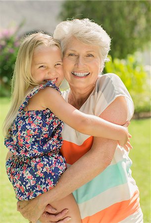 Older woman holding granddaughter in backyard Stock Photo - Premium Royalty-Free, Code: 6113-07159705