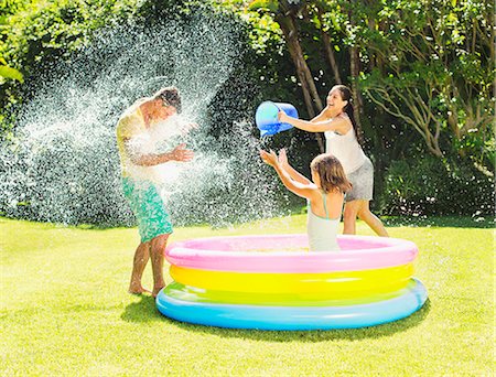 family yard - Family tossing water on father in backyard Stock Photo - Premium Royalty-Free, Code: 6113-07159731