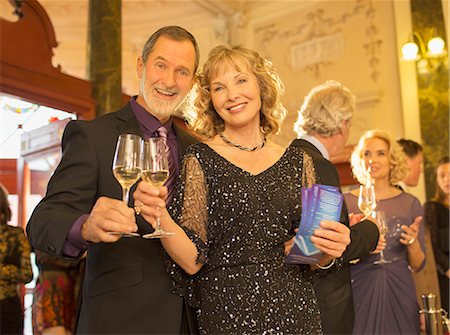 simsearch:6113-07543617,k - Portrait of well dressed couple toasting champagne flutes in theater lobby Stock Photo - Premium Royalty-Free, Code: 6113-07160045